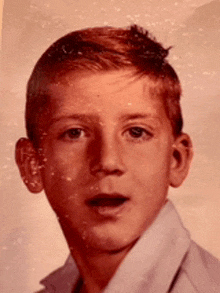 a young boy with red hair is looking at the camera