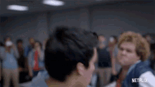 a man is throwing a punch at another man in front of a crowd .