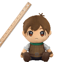 a stuffed toy is sitting next to a ruler which goes up to 12 inches