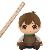 a stuffed toy is sitting next to a ruler which goes up to 12 inches