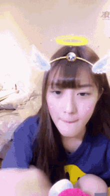 a girl wearing a headband with angel wings and a halo on her head
