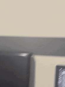 a blurry picture of a person sitting at a desk with a computer .