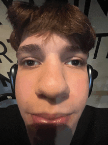 a close up of a person 's face with the letter r in the background