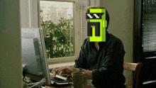 a man sitting in front of a computer with a pixelated face that says ' n ' on it