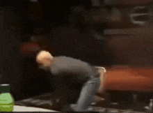 a man in a black shirt is dancing in front of a sign that says ' i love you ' on it .