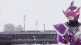 a man in a purple and pink costume is holding a sword in front of a bridge .