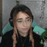 a woman wearing headphones and glasses is looking down