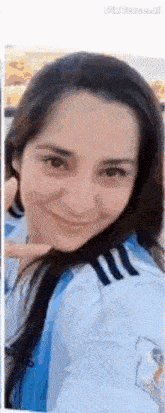 a close up of a woman 's face with a blue and white shirt on .