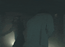 a man and a woman are standing in the dark