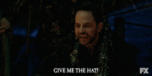 a man says " give me the hat " in front of an fx logo