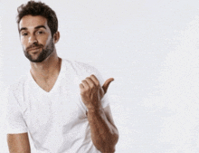 a man in a white t-shirt giving a thumbs up
