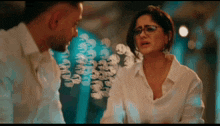 a man and a woman are looking at each other with a blurry background