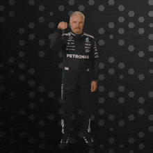 a man with a mustache is wearing a petronas racing suit