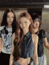 three girls are standing next to each other in front of a sign that says exit