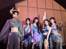 a group of women are posing for a picture and one of them has a crown on her head