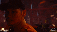 a man in a hat is standing next to a woman in a disney + ad