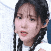 a close up of a woman 's face with a kbs logo in the background