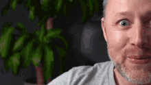 a man with a beard is making a funny face while looking at the camera .