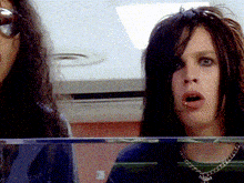 a man with a piercing in his lip is standing next to a woman with long hair