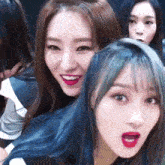 a group of girls with blue hair are posing for a picture together .