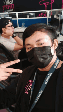 a man wearing a mask and a lanyard that says ' eoiole '