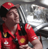 a man wearing a red shirt with the word shell on the sleeve