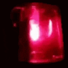 a close up of a red light in the dark with a white light coming out of it .