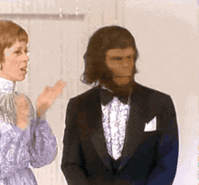 a man in a tuxedo is standing next to a woman