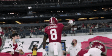 a football player with the number 8 on his jersey stands on the field