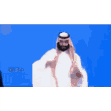 a man in a traditional arabic costume is standing next to another man in a suit .