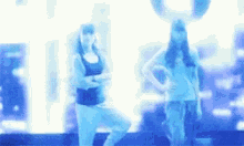 two women are standing next to each other in a blurry photo .