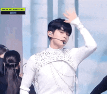 a man in a white shirt is dancing on a stage with a microphone .