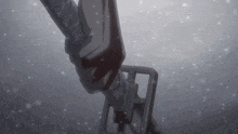 a close up of a sword with snow falling on it