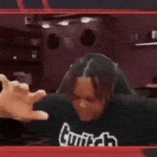 a man in a black shirt is sitting in a chair in a wrestling ring .