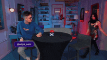a woman sitting at a table with a red button that says " какого хуя ? "