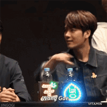 a man covering his face with his hands and a sign that says wang gae in front of him