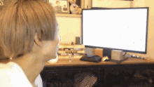 a person sitting in front of a computer with a stack of storage boxes