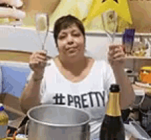 a woman in a pretty shirt is holding a glass of champagne and a spoon .