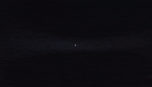 a blurred image of a person standing in a dark room with a light shining on them