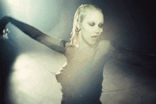 a woman with white paint on her face is standing in a dark room