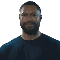 a man with a beard wearing a blue shirt smiles