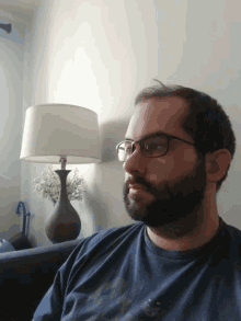 a man with glasses and a beard is laying down