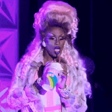 drag queen drinking through a straw from a cup