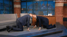 two men on their knees in front of a desk with the words late night seth