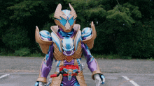 a man in a purple and gold costume with a red belt is standing in a parking lot