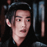 a close up of a young man with long hair
