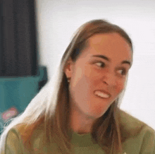 a woman with long hair is making a funny face while looking at the camera .