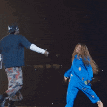 a man wearing a dodgers hat is dancing with a woman