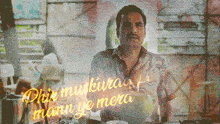 a man sitting at a table with the words " phir muskuraa mann ye mera " written in yellow