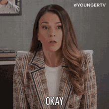 a woman in a suit says okay in front of a youngertv logo